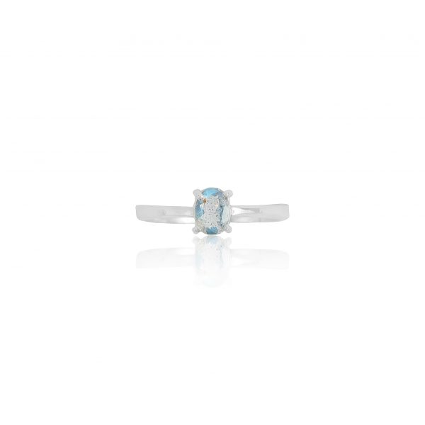 A sterling silver solitaire ring featuring an oval-cut labradorite gemstone with a blue iridescent glow, displayed on a soft white reflective surface.